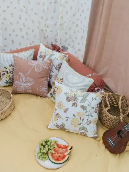 A picnic setup featuring our blush-toned and floral cushion covers. They add comfort and style to any setting, whether it's your living room or an outdoor gathering.