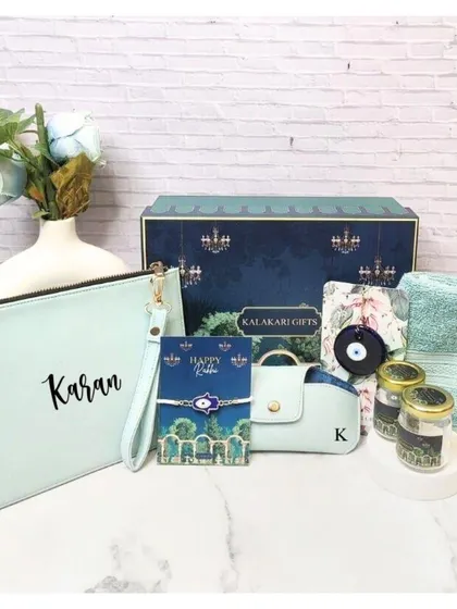 A sophisticated Rakhi hamper for a brother, featuring a personalized pouch, an evil eye rakhi, an eyewear case, and other curated items in a cool mint green theme.