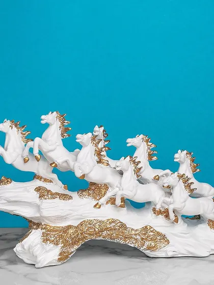 This powerful sculpture of seven running horses, crafted in white with gold manes, symbolizes success and forward momentum. It's a Vastu-compliant piece that is both beautiful and meaningful.