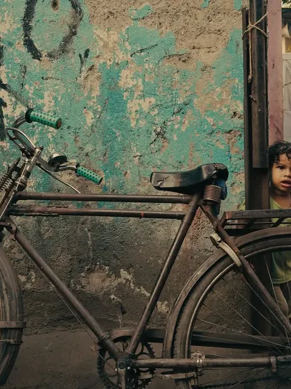 Street photography is about noticing the small stories. A child's curious glance from behind a bicycle against a textured wall is a raw, authentic moment that speaks volumes. It’s this kind of unscripted magic I aim to capture.