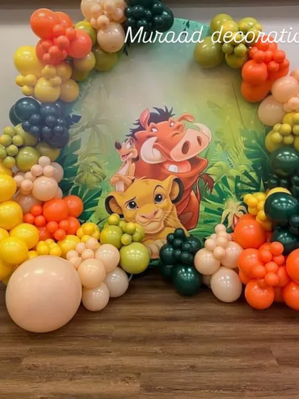 This circular backdrop features Simba, Timon, and Pumbaa, framed by a colorful organic balloon garland. It’s a fantastic focal point for a jungle or Hakuna Matata themed birthday party.