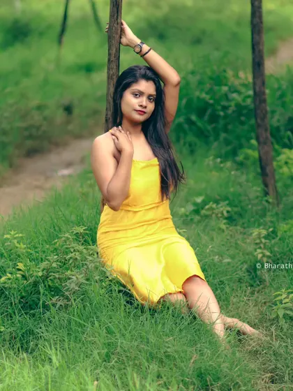 A relaxed, reclining pose in the grass. This is a great example of a casual and comfortable outdoor lifestyle portrait.