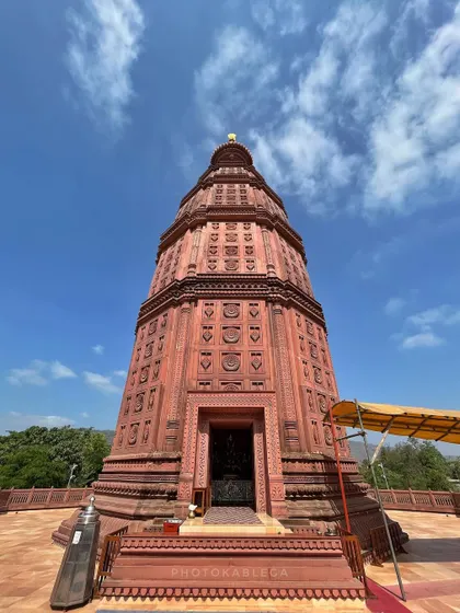 The impressive red stone temple tower against a clear blue sky.