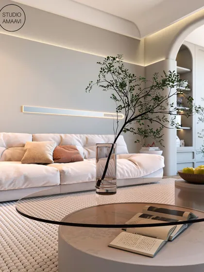 A close-up on the details. A simple glass vase with a single branch sits on a glass-topped coffee table, reflecting our belief that luxury can be found in the simplest, most natural elements. The textured rug adds warmth and comfort underfoot.