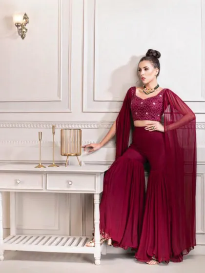 This look is for the modern bride who loves contemporary silhouettes. I styled this deep maroon sharara set, featuring dramatic cape sleeves and an embellished crop top, for a chic Sangeet or cocktail event.