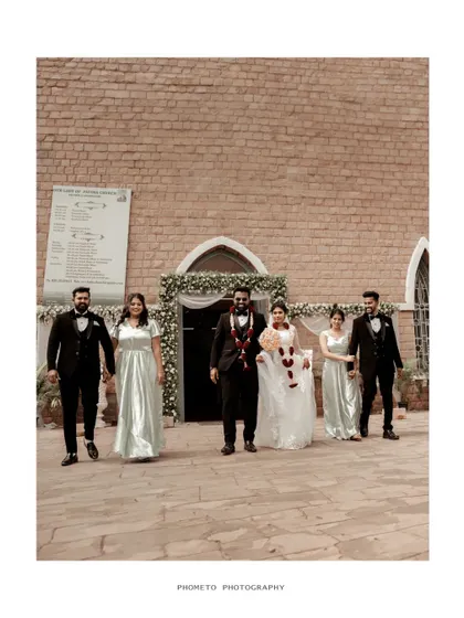 The wedding party exits the church, a happy and classic moment captured in a clean, bright style.