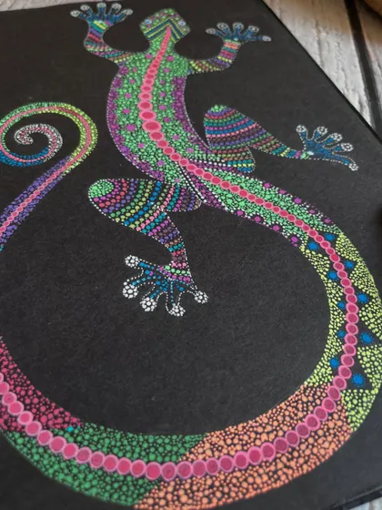 A close-up shot of the intricate dot work on the lizard stippling art.
