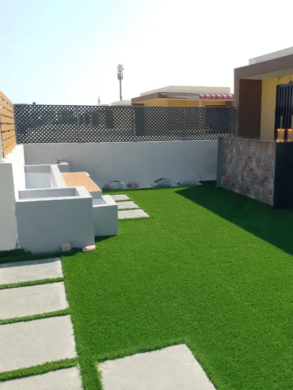 This shows the start of a great party place on a roof. We've laid down lush artificial grass and added built-in seating, creating a foundation for a versatile space for kids' parties or family get-togethers.