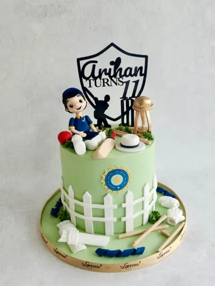 A cricket-themed cake for Arihan's 11th birthday, with a fondant figurine, a picket fence, and cricket equipment.