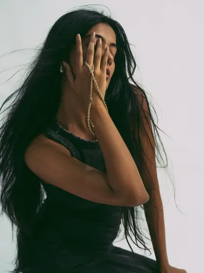 An expressive shot where the model's hand and hair create a sense of mystery.