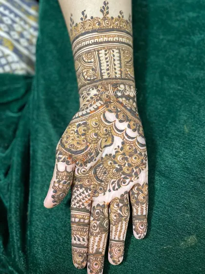 A single hand showing a full, intricate design with a heavy cuff and detailed palm work.