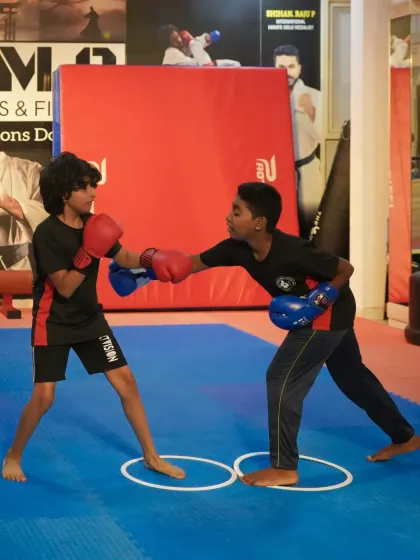 Our youth boxing program teaches more than just how to punch; it builds discipline and strategic thinking. Here, two young fighters practice their sparring techniques, learning footwork and defense under the watchful eye of our coaches.