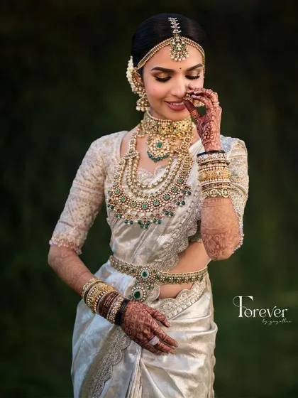 A candid moment of the bride, her smile lighting up her face. The makeup is designed to look flawless from every angle, capturing her joy perfectly.