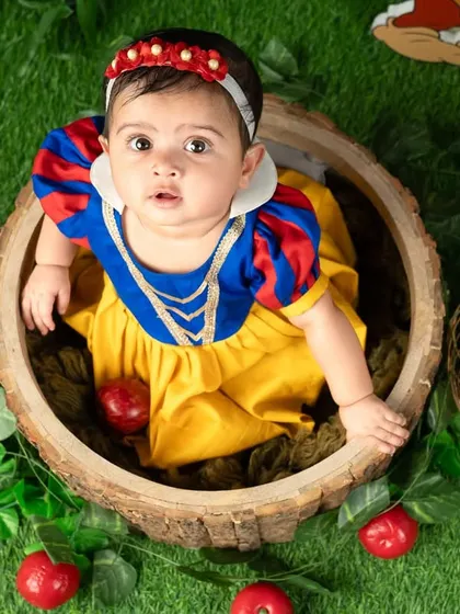A curious glance from our little Snow White, peeking out of a wooden barrel prop.