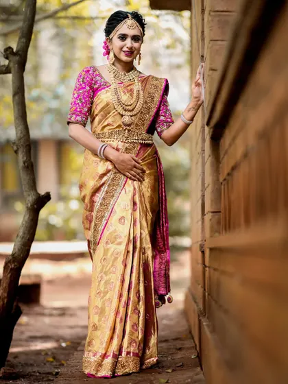 A full-length shot showing how the jewellery and the golden-hued saree come together for a regal and elegant bridal style.