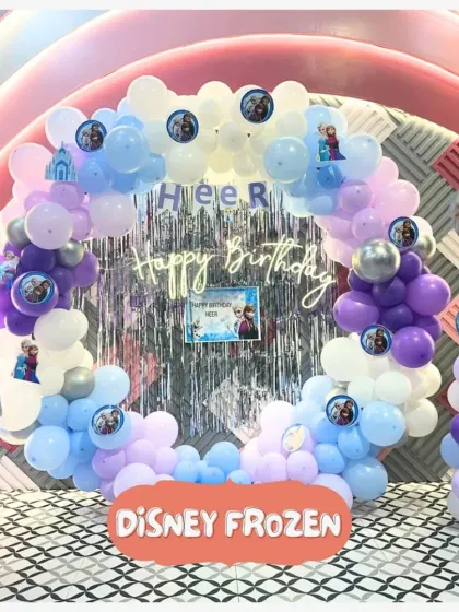 An enchanting Disney Frozen birthday setup! This beautiful balloon arch with Anna and Elsa cutouts creates the perfect icy kingdom for a magical celebration.