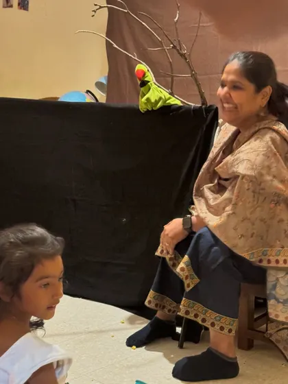 A happy moment watching the children's reactions during a puppet show. Their engagement and wonder are what make these sessions so special. I use a variety of puppets, including this parrot, to create a lively narrative.