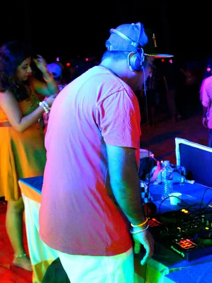 A close-up of the DJ spinning tracks at a beach party, ensuring the energy stays high all night long.
