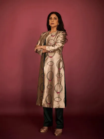 A powerful, arms-crossed stance that emphasizes the structured feel of this elegant Indian-wear jacket.