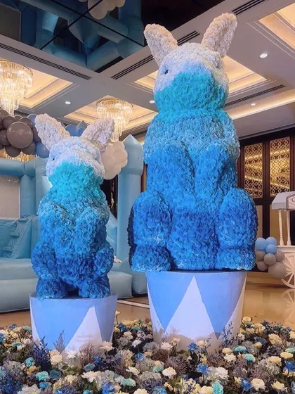Giant floral bunnies in shades of blue and white add a soft, whimsical touch to the carnival theme. These custom floral sculptures are a unique way to incorporate flowers into a child's party.