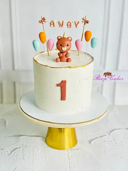 Sweet and simple. A charming teddy bear cake to celebrate a baby's very first birthday, featuring a cute fondant bear and colorful balloons.