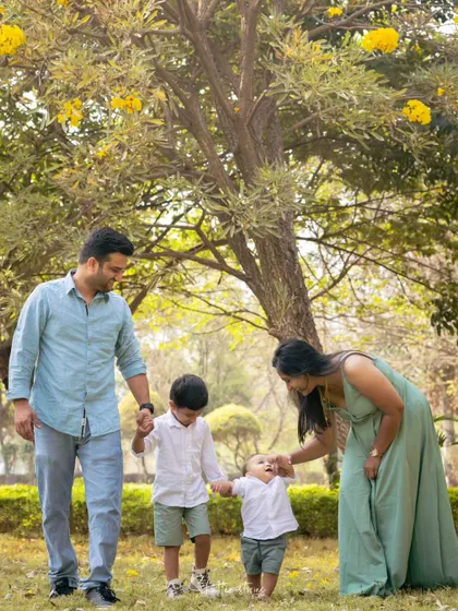 A candid shot of the family walking together in the park, holding hands.
