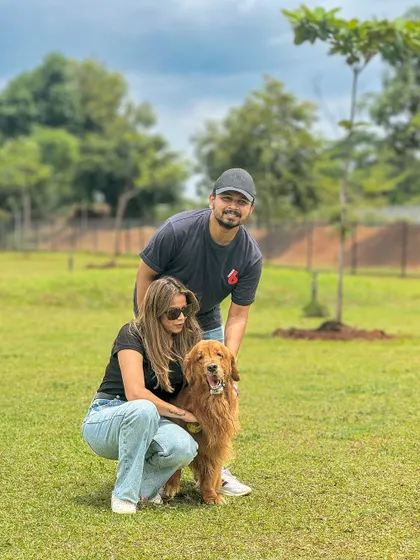 A happy couple posing with their beautiful Golden Retriever. It's the perfect spot for a family photo.