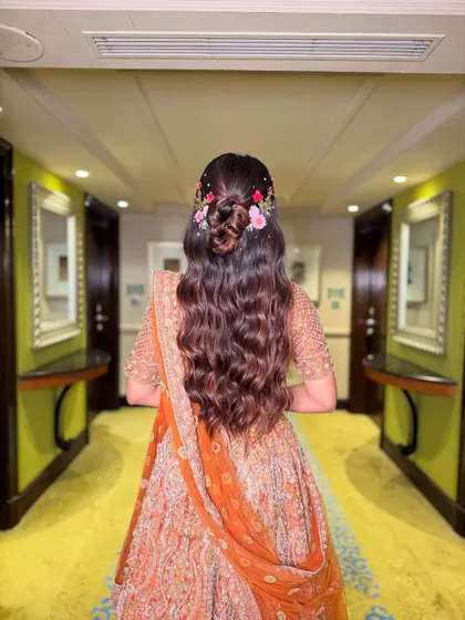 For a dreamy and romantic vibe, I styled these long, flowing waves into a half-up bun, delicately weaving in fresh flowers. This look is effortlessly beautiful and perfect for an outdoor or daytime ceremony.