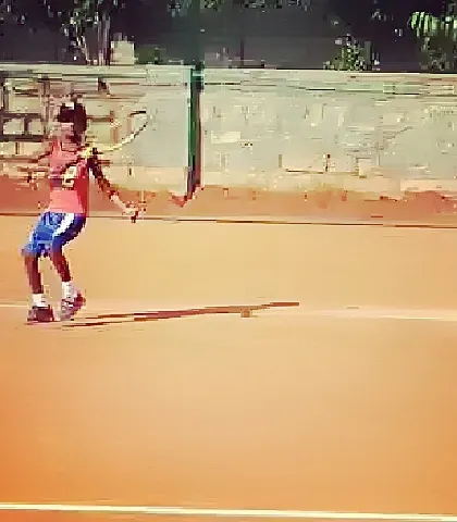 A young advanced player demonstrates excellent form and follow-through on his forehand.