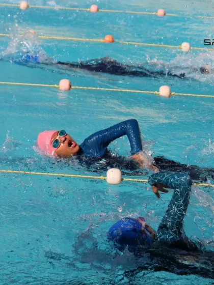 Two swimmers race side-by-side during a practice session. This friendly competition helps our athletes push themselves and prepare for the pressures of a real swim meet.