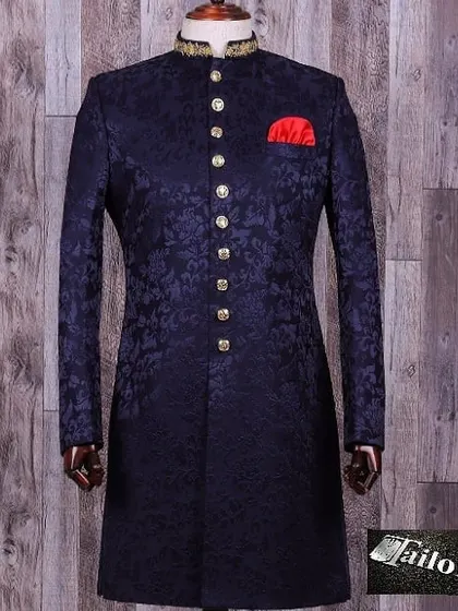 A royal blue brocade sherwani with intricate self-design and gold buttons. The embroidered collar adds a touch of luxury, making it ideal for a groom.