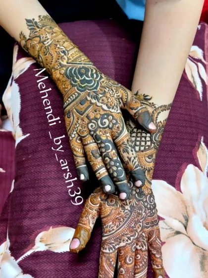 A detailed view of a bridal henna design covering the hands and wrists. The use of both fine lines and bold fills creates a rich, textured appearance.