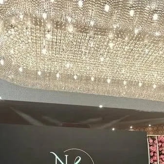 A magnificent crystal chandelier illuminates a venue, showcasing our ability to incorporate high-end lighting fixtures into our event designs for a touch of elegance.
