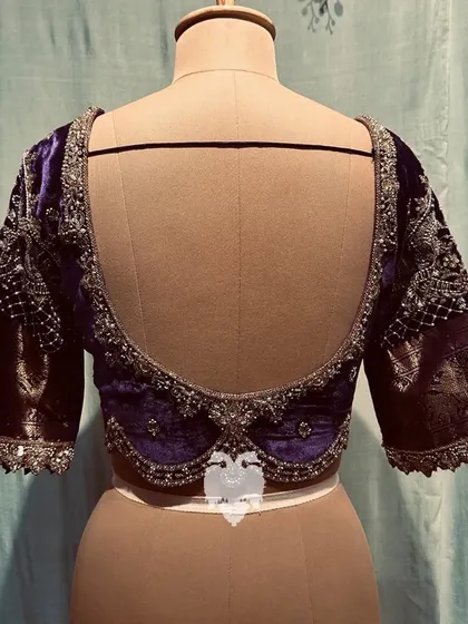 The elegant deep U-back of the violet velvet blouse.