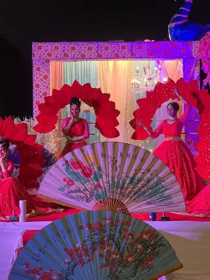 A duplicate image of our dancers at a Grand Varmala ceremony, showcasing the vibrant red costumes and props.