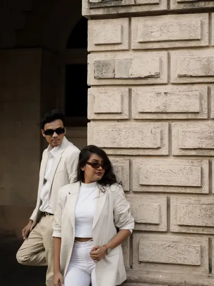 A chic and moody portrait against a stone wall. Their sunglasses and confident poses give this a very stylish, modern feel.