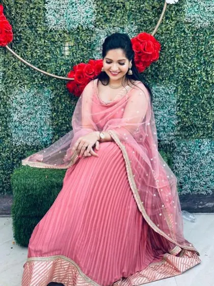 A simple and elegant pleated pink gown with a delicate embroidered border. This is a comfortable and chic rental option for any party.