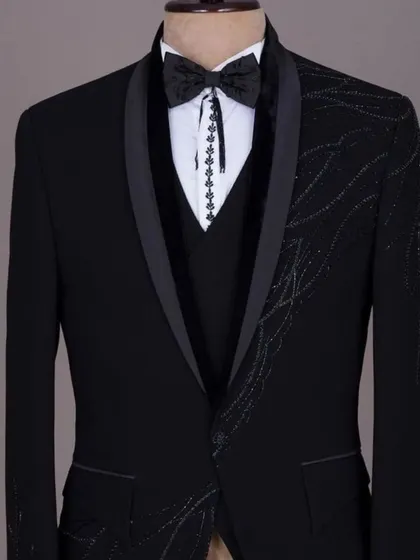 A black tuxedo with unique, asymmetrical sequin work. This is a modern and artistic take on formal wear.
