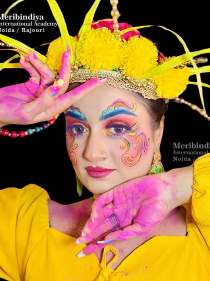 A vibrant and creative look for Holi, with the hair styled in an elaborate updo featuring yellow pom-poms and colorful accessories.