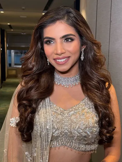 A happy, smiling portrait of the bride at her reception. The makeup is glamorous yet feels light and comfortable, allowing her natural beauty to shine.