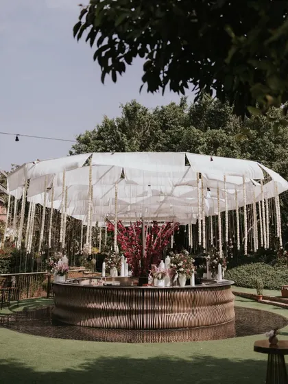 Our circular bar decorated for a daytime event, with a canopy of white fabric and hanging floral strings.