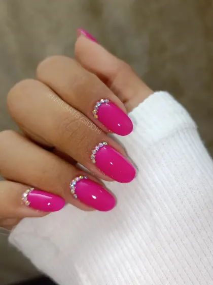 A bright magenta polish with a simple, elegant half-moon of sparkling crystals at the cuticle.