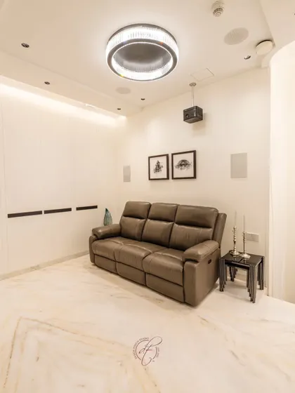 A wide shot of the home theater, showcasing the clean lines, marble flooring, and thoughtfully designed lighting that complete the cozy and high-end atmosphere.