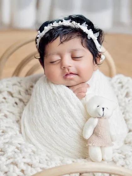A close-up of a sleeping baby on a cozy knit blanket, cuddling a small teddy bear. The simplicity of this shot is what makes it so timeless.