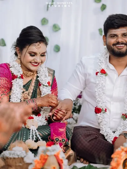 A candid moment during the engagement ceremony, with the couple sharing a smile as they participate in the rituals.