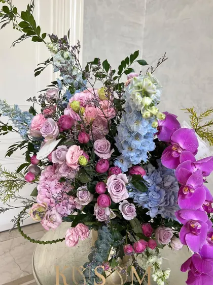 This arrangement is inspired by the sweet, soft daydreams of vintage romantic novels. I paired Kenyan delphiniums and Dutch Phalaenopsis orchids with berry and lilac roses for a truly fairytale look.