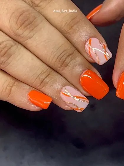 A close-up of the orange and glitter swirl accent nails.