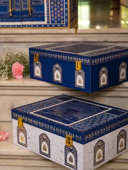 A closer look at the beautiful gift boxes from the Golden Dunes collection. The contrast of royal blue and pristine white, both adorned with architectural motifs, showcases the theme's versatility and elegance.