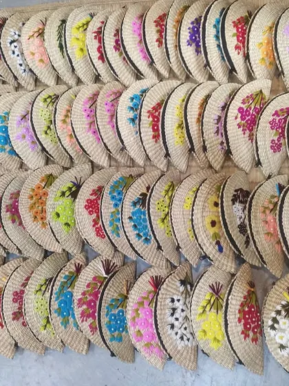 An impressive display of our handcrafted fan-shaped clutches, ready for shipping. The sheer variety in color and floral embroidery highlights the custom, artisanal nature of our products, perfect for bulk orders and unique gifting.