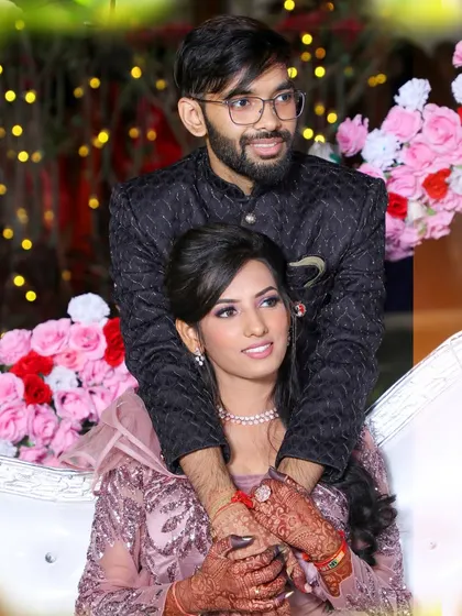 A posed reception photo capturing the couple's connection, set against a backdrop of flowers and lights.